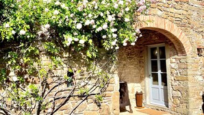 A stone building with a brick chimney, a window, and a door. - La Locanda Volpaia (Radda in Chianti)