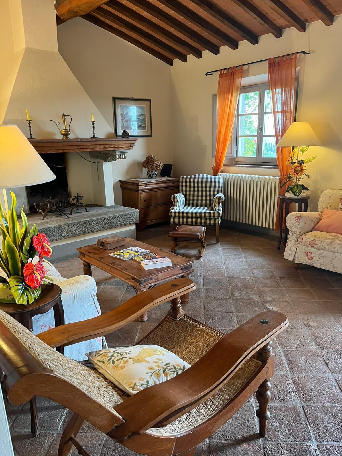 A cozy living room with a fireplace, wooden furniture, and a view of the outdoors.