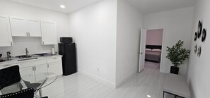 Efficient living space with a clear view of the adjacent bedroom, featuring a seating area and a well-equipped kitchen.