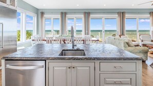 A kitchen with a large island, a sink, and a view of the ocean. - Island Escape - Beach front, Private Pool, Pet Friendly and Fully Renovated! (St. George Island)