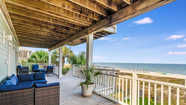 A wooden deck with outdoor furniture, a potted plant, and a view of the beach. - Island Escape - Beach front, Private Pool, Pet Friendly and Fully Renovated! (St. George Island)