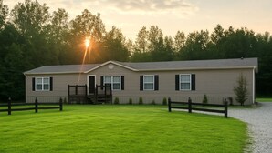 A two-story house with a front porch and a fenced yard.