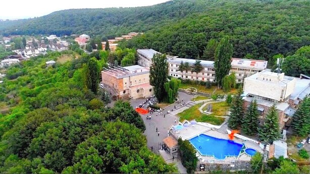 An aerial view of a campus with buildings, a swimming pool, and surrounding greenery. - Writers hotel in Tsaghkadzor (Tsaghkadzor)