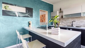 Une cuisine moderne avec un mur d’accent de couleur turquoise, un îlot central et un évier.