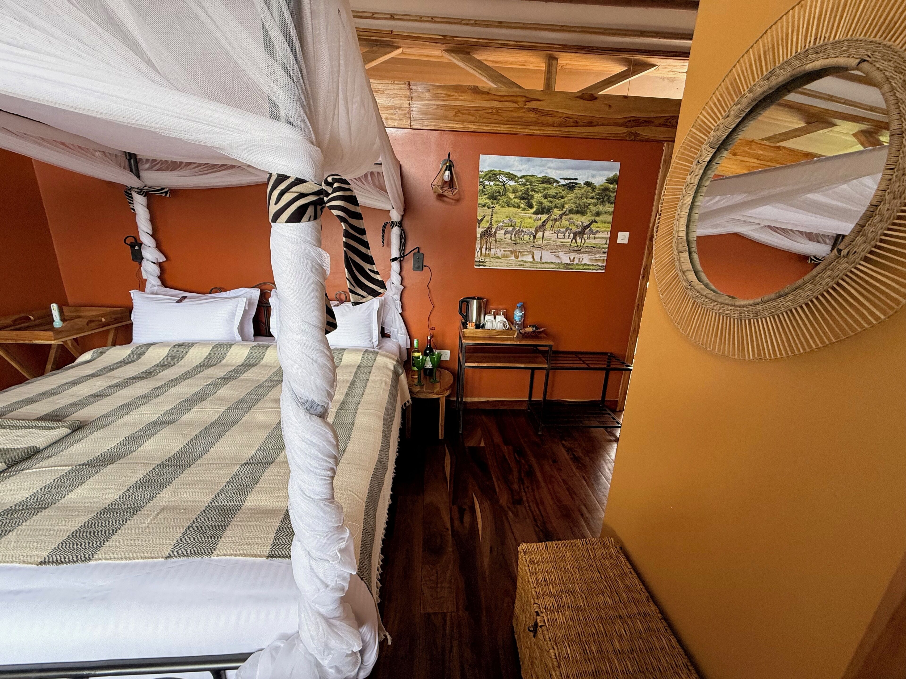 A room with a bed, a small table with a mirror, and a picture on the wall.
