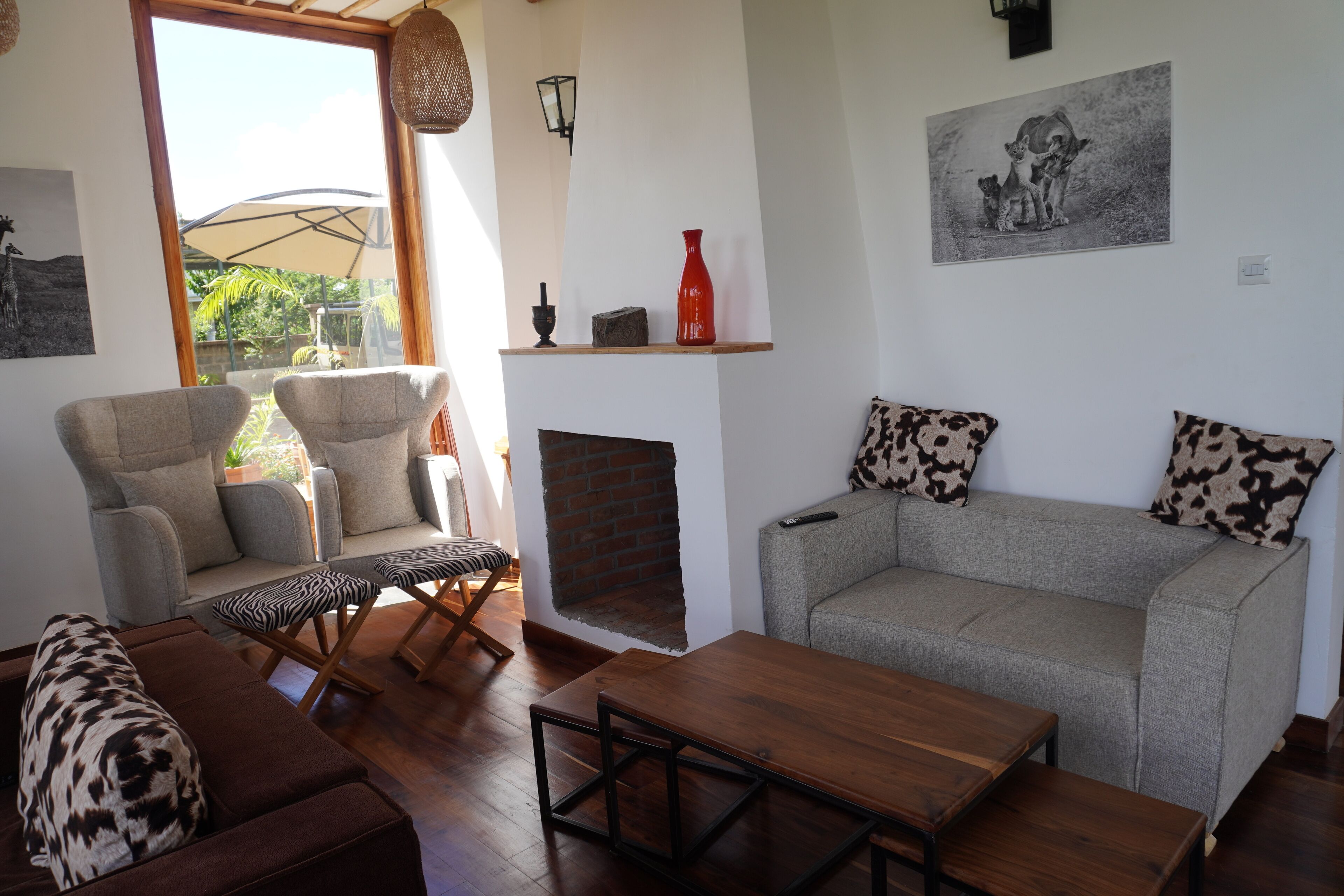 A living room with a sofa, armchairs, a wooden table, and a fireplace.