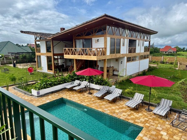Ein zweistöckiges Haus mit Pool, Außenbereich und Garten.