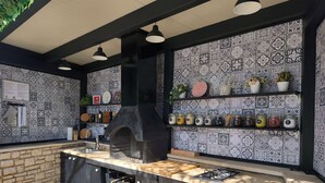 Une cuisine dotée d’un four encastré, d’un plan de travail en pierre et de carreaux décoratifs.