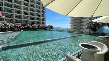 Una piscina al aire libre, sombrillas, guardavidas en la propiedad