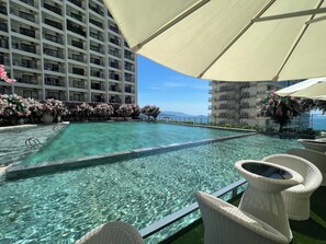 Una piscina al aire libre, sombrillas, guardavidas en la propiedad
