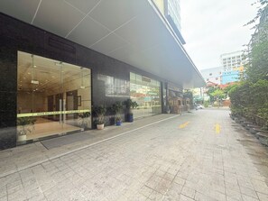 A modern building with a glass facade, labeled "GOLDCOAST APARTMENT." - Apartment Lotte (Nha Trang)