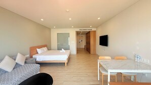 A hotel room with a bed, a desk, a chair, and a television.