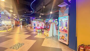 Een overdekte speelhal met grijpmachines en een foodcourt.