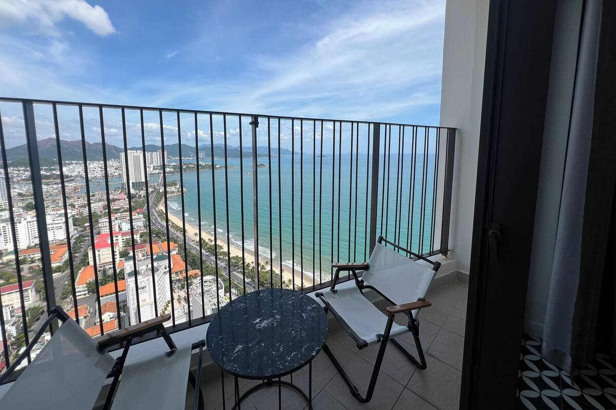 A balcony with a view of a beach and cityscape.