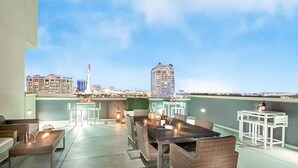 Une terrasse sur le toit comprenant un espace repas, des sièges et une vue sur le panorama urbain.