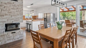 A modern kitchen with a stone wall, wooden dining table, and bar stools. - **Villa Admiral: Your Idyllic Retreat in rural area of Trogir hinterland** (Blizna Gornja)