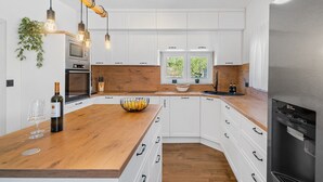 A modern kitchen with white cabinets, a wooden countertop, and a built-in oven. - **Villa Admiral: Your Idyllic Retreat in rural area of Trogir hinterland** (Blizna Gornja)