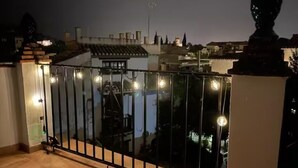 Een balkon met een metalen hekwerk en lichtjes.