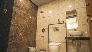 A modern bathroom with a marble floor, a toilet, a sink, and a shower. - Bhopal Inn by Ten On Ten Stays (Bhopal)