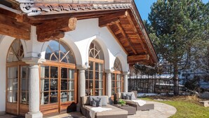 A building with a stone facade, large arched windows, and wooden beams.