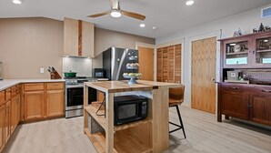 Una cocina moderna con armarios de madera, un microondas integrado y una isla central.