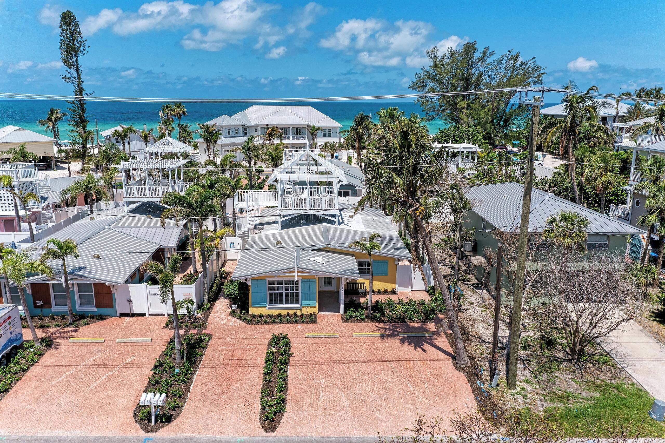 A coastal residential area with multiple houses, some with balconies, and a clear view of the ocean.