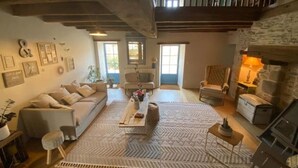 A cozy living room with a sofa, coffee table, and chairs. There are framed pictures on the wall and a fireplace. - Exceptional eco-domain (spa&pool) (Le retail)