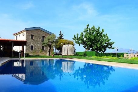 Una piscina al aire libre de temporada, sombrillas