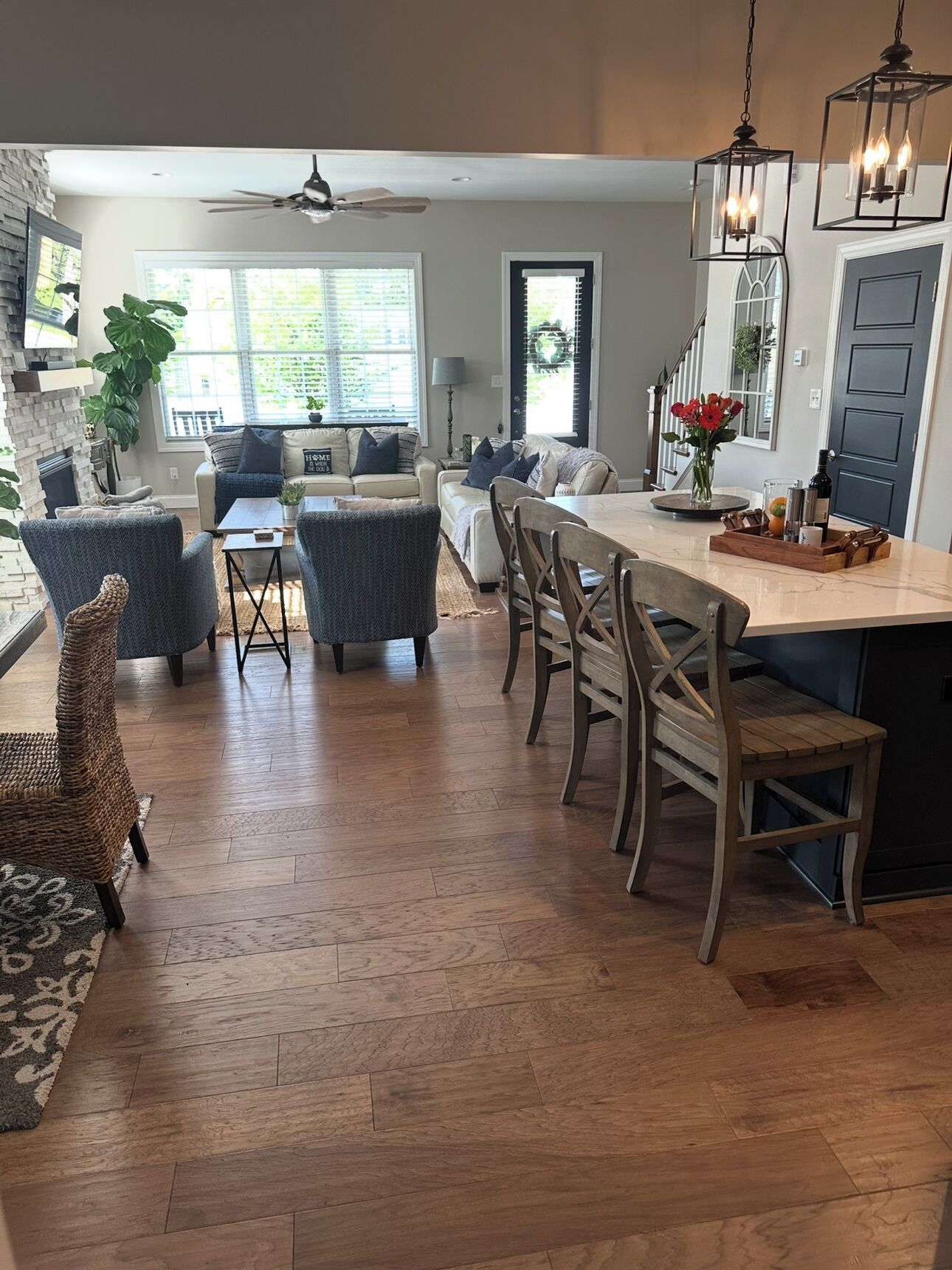 Un grand espace de vie doté d’une cheminée, d’une table à manger avec des chaises et d’un coin cuisine équipé d’un réfrigérateur.