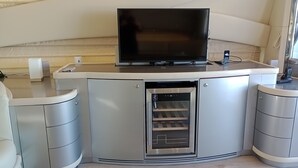 Een moderne keuken met een ingebouwde oven, een televisie en een koffieapparaat.