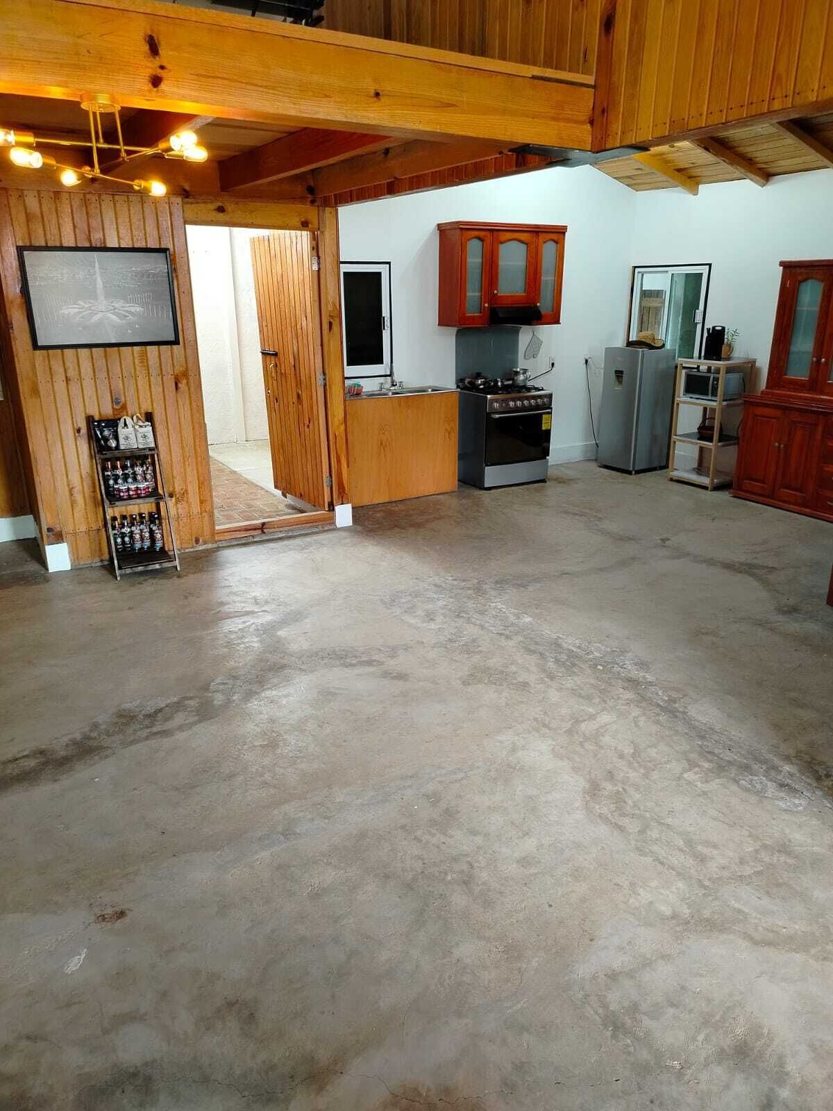 A spacious kitchen with wooden cabinets, a refrigerator, and a sink.
