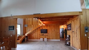 A wooden interior with a staircase, a flat-screen TV, and a shoe rack. - Punta Paraíso Oaxaca (Oaxaca)