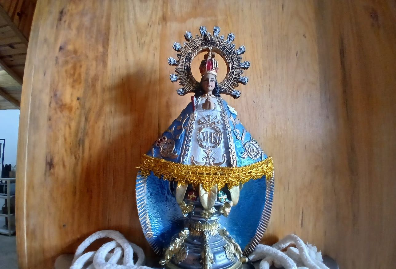 A statue of a religious figure with a halo, placed on a stand with a chain.