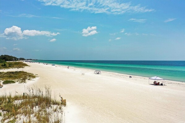 Relax on the beach with comfortable seating and umbrellas.