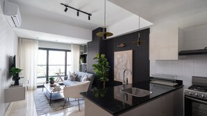 Eine moderne Küche mit einer zentralen Kochinsel, einem eingebauten Backofen und einem Essbereich mit einer Couch und einem Couchtisch.