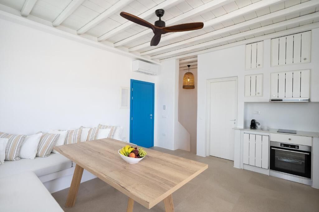 A modern kitchen with white cabinetry, a built-in oven, and a ceiling fan.
