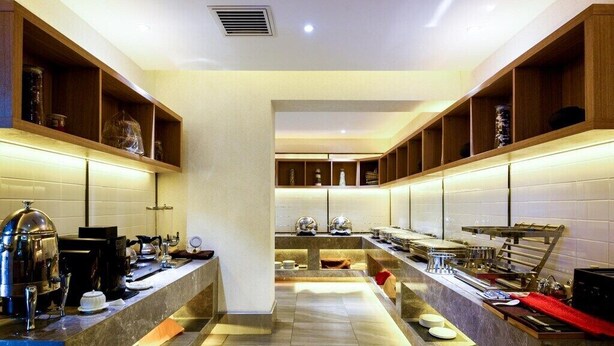 A modern kitchen with marble countertops, built-in shelves, and a central island. - Qiuguo Hotel Beijing by Bayluxury (Beijing)