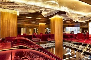 A hotel lobby with escalators, red seating, and a modern ceiling design. - The Marmara Taksim (Istanbul)