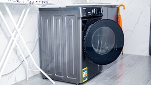 A compact, modern washing machine with a front-loading door, situated in a clean, well-lit laundry room with a tiled floor and a white wall. - Tranquil, Secure Haven in the Heart of Harare. (Harare)
