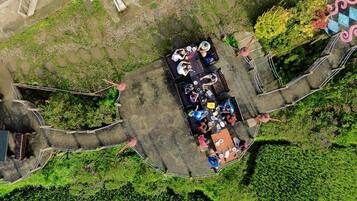 An aerial view of a garden with a dining area, surrounded by pathways and greenery.