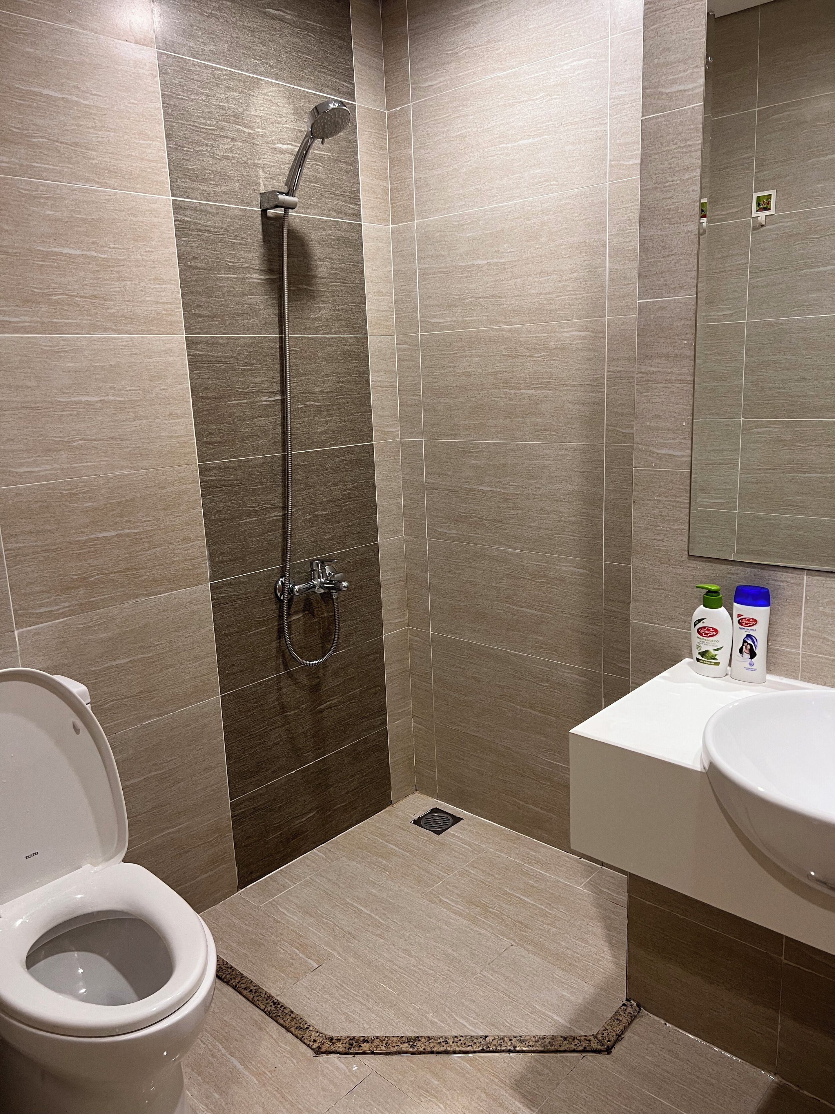 A bathroom with a shower, toilet, and sink.