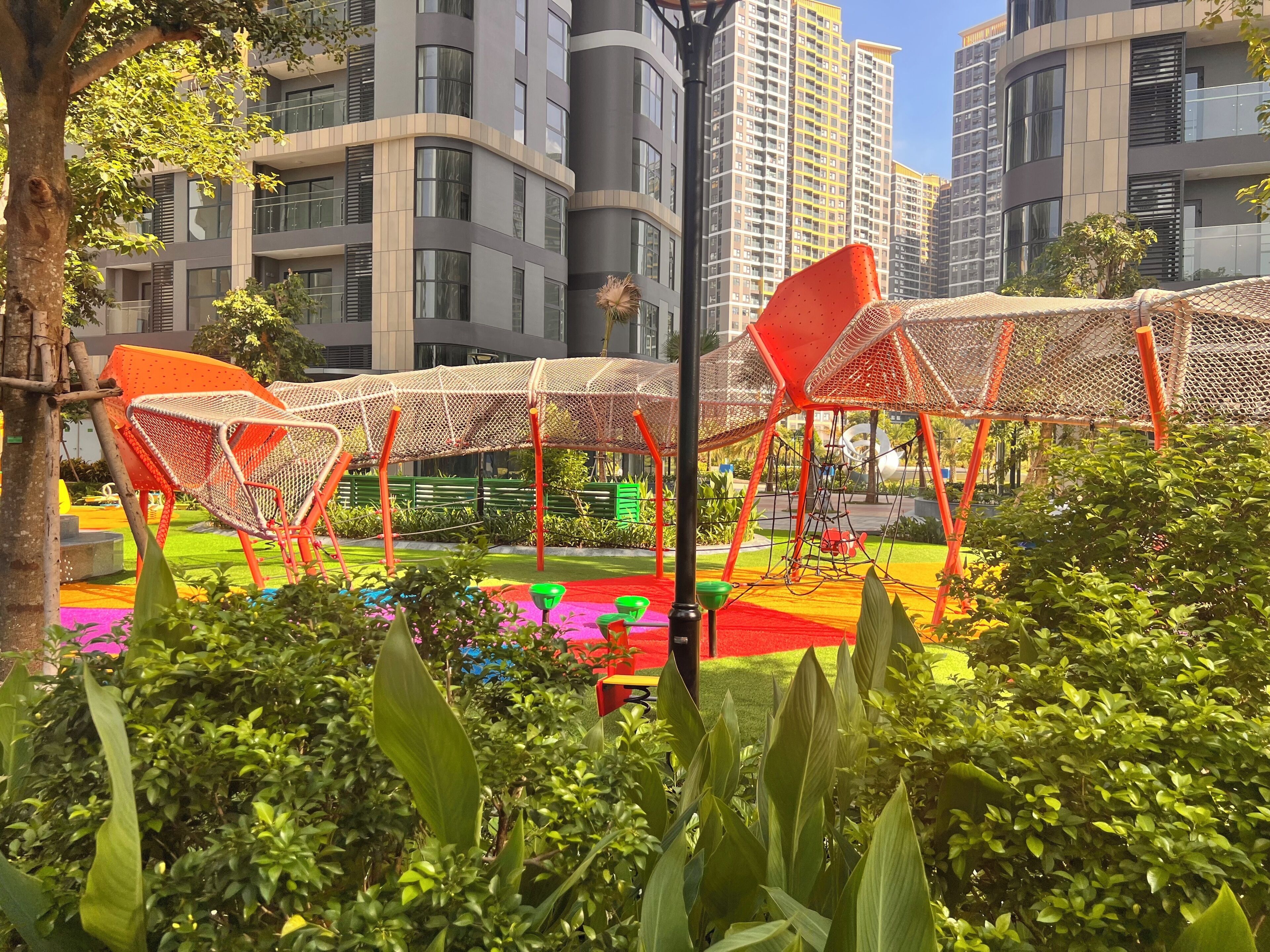 Un parque urbano moderno con asientos exteriores y una zona de juegos.