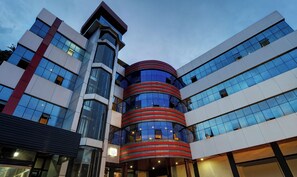 A modern building with a cylindrical central section, multiple floors, and large windows. - Sparrows Residency (Kattappana)