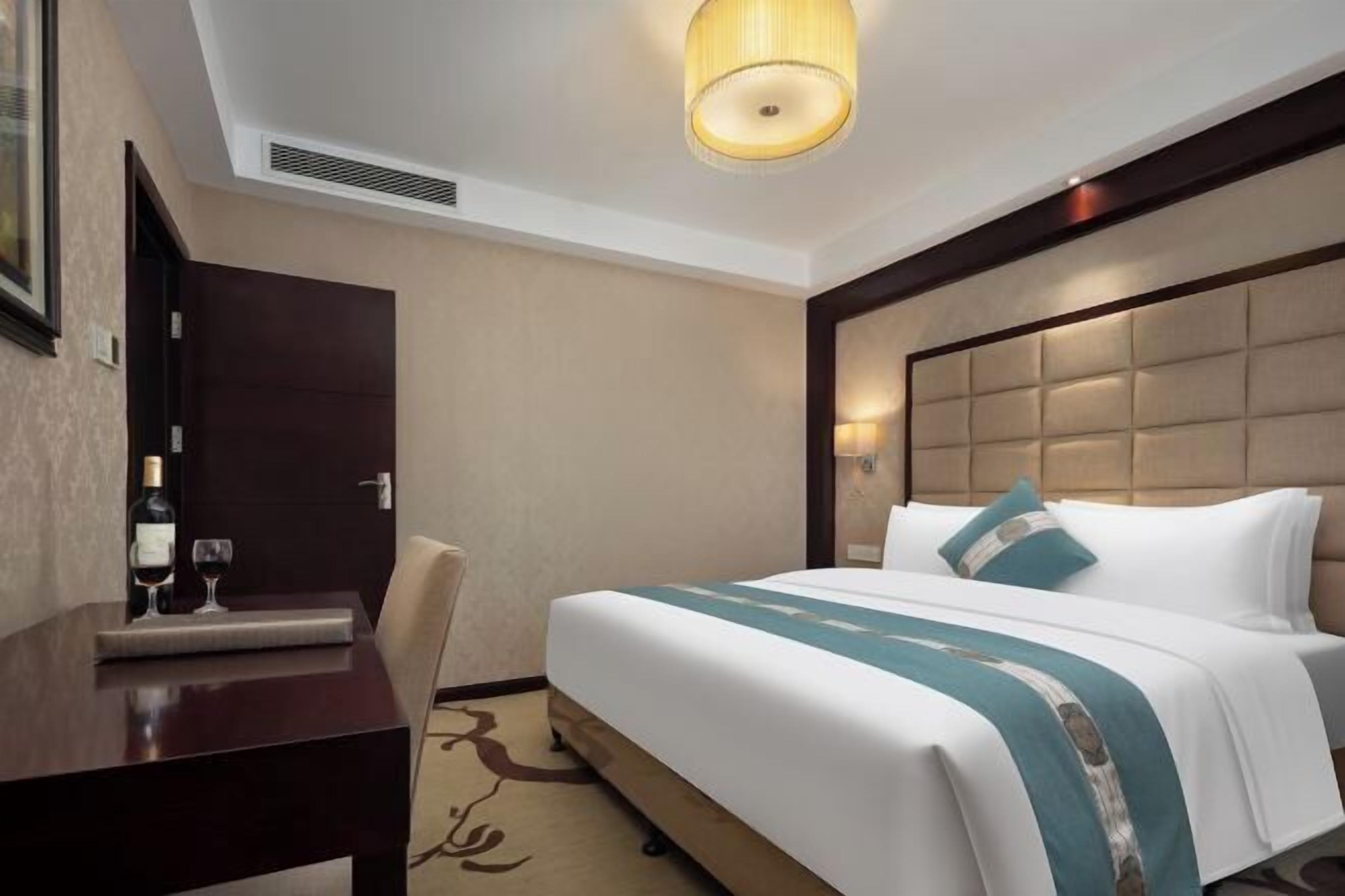 Una habitación de hotel con una cama, un escritorio y una silla.