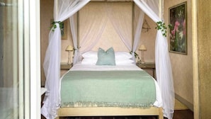 A four-poster canopy bed with a green bedspread and a single teal pillow. - Le Pigeonnier du Bordial (Molières)