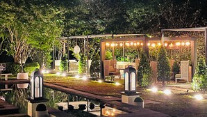Ein Gartenbereich mit Sitzgelegenheit, einem kleinen Pavillon und einem Weg.