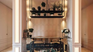 A modern interior with a glass-top table, potted plants, and a patterned carpet. - The Westlight: Bright LG Studio in White City (London)