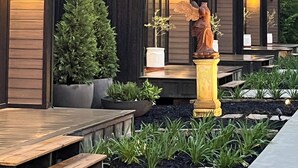 Una hilera de edificios modernos de varios pisos con fachadas de madera oscura y techos inclinados.