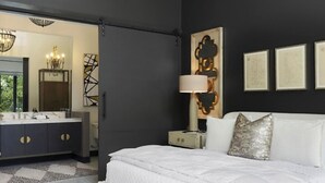 Un dormitorio moderno con una cama grande, un tocador con espejo y un ventilador de techo.