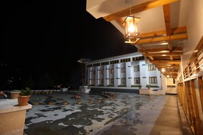 A building with a modern design, featuring a courtyard with a fountain and potted plants. - Resort Thim Dorji (Paro)